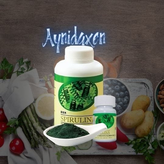 pomo de Tabletas de Spirulina de DXN en dos tamaños con una cuchara de spirulina en polvo.