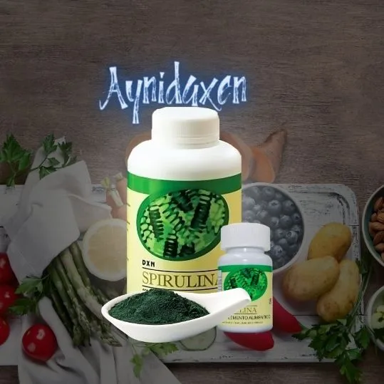 pomo de Tabletas de Spirulina de DXN en dos tamaños con una cuchara de spirulina en polvo.