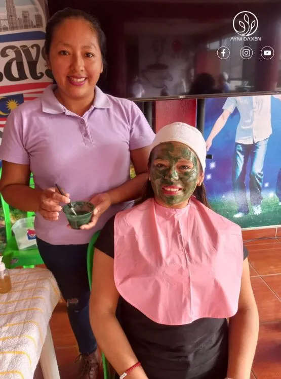 mascarilla de Spirulina color verde de DXN una persona que aplica y el modelo con los utensilios necesarios.
