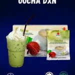 DXN Oocha en la caja más un vaso de té, con hojas de te Oolong, sobre de oocha.